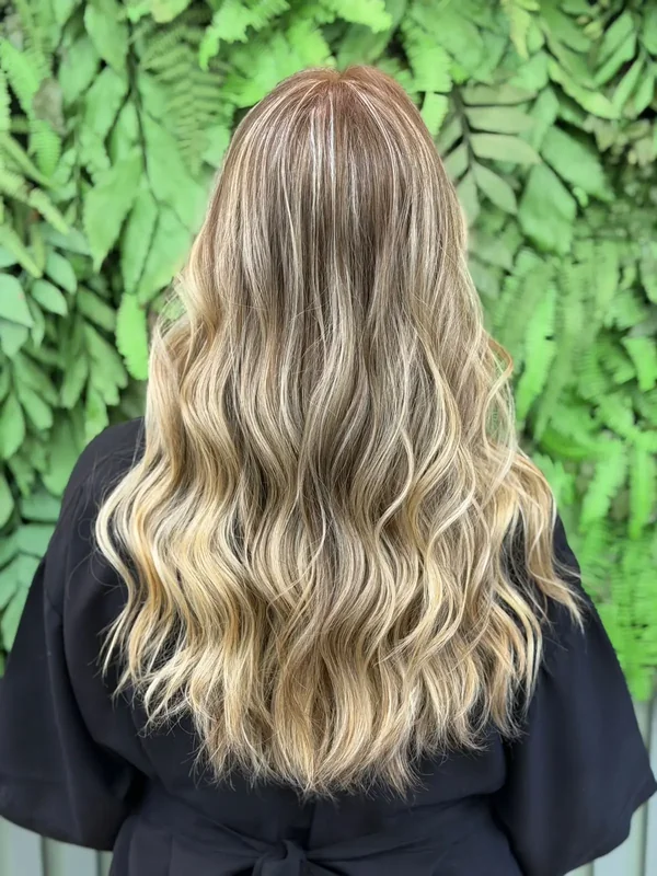 Cabelo loiro com mechas e ondas, visto de costas